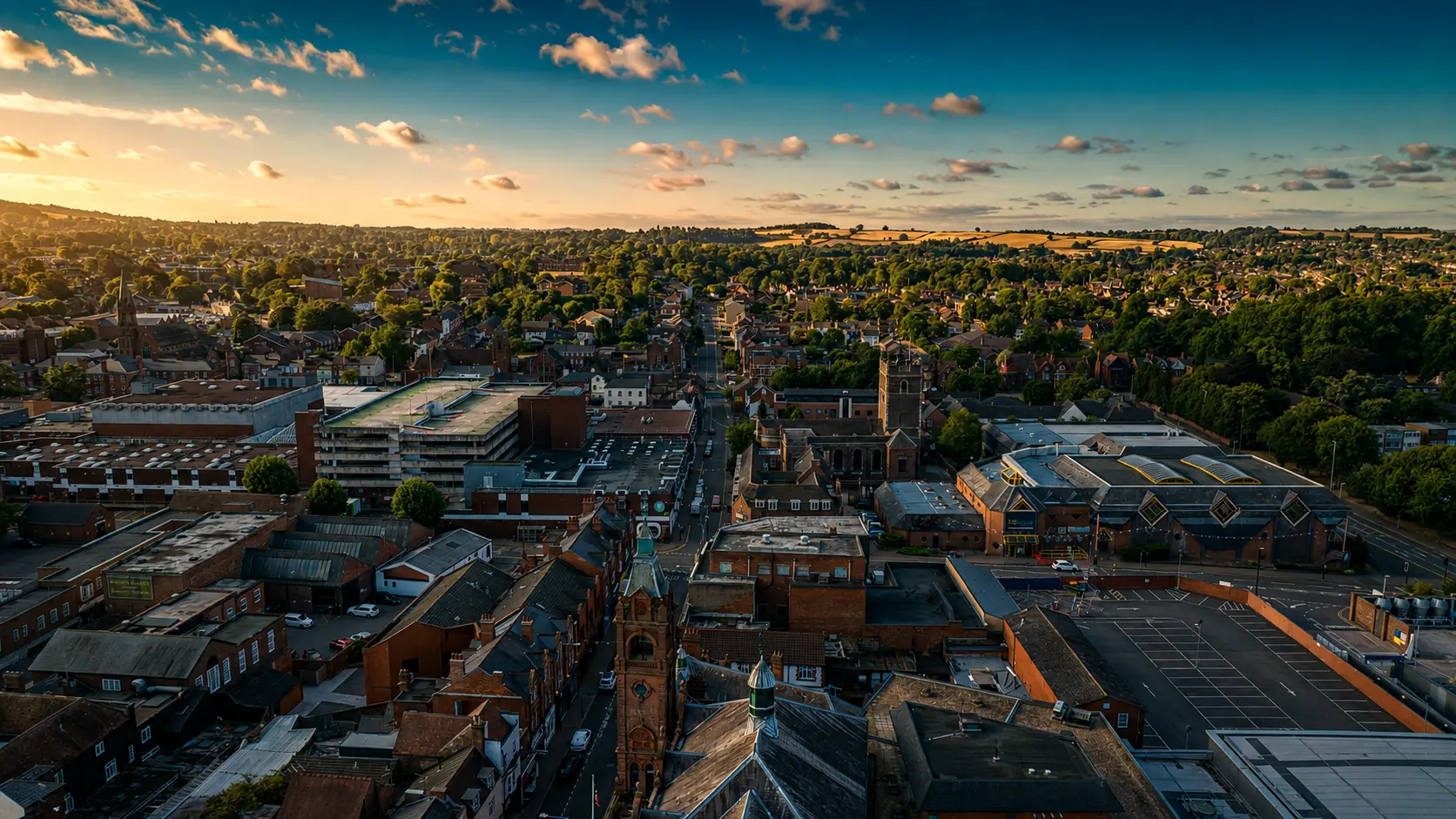 Aerial view over Stourbridge rooftops and clock tower at sunset