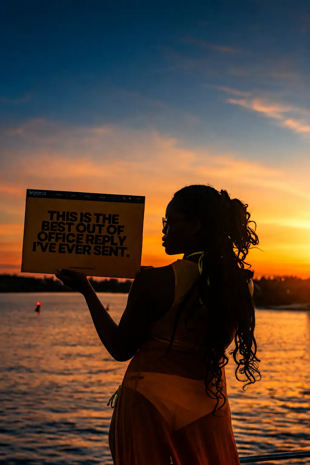 Silhouetted woman at sunset holding a card reading the best out of office reply I've ever sent